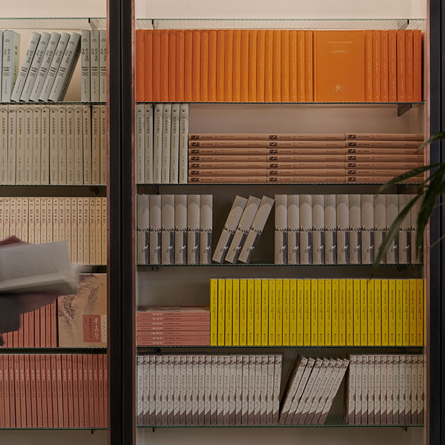  Warm wooden shelves filled with yellow, orange, and red books.